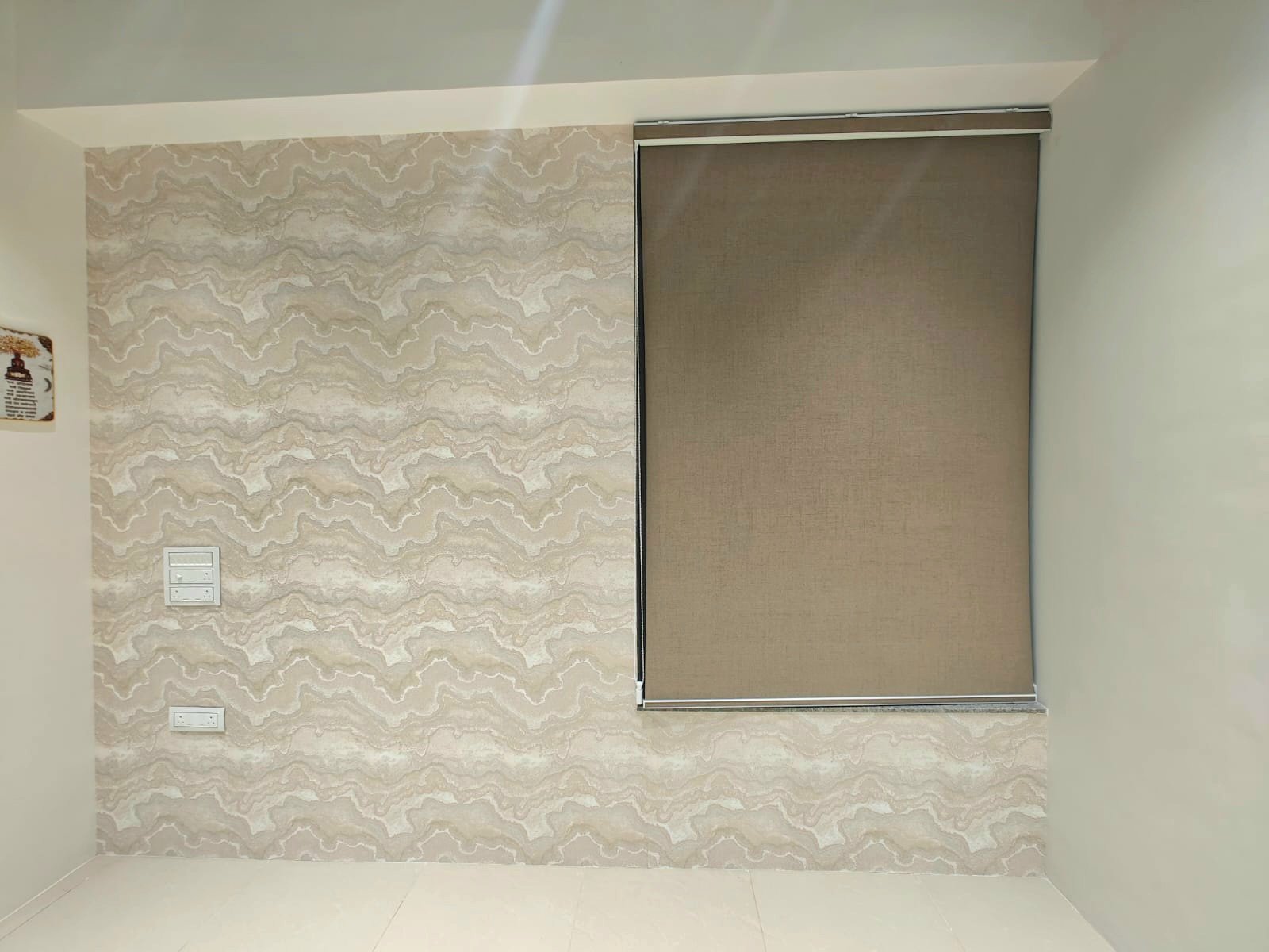 A textured stone-effect wall with a roller blind over the window